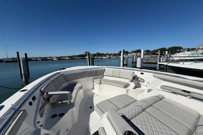 Slide: The Image of 2023 Pursuit S 428 Sport boat interior with luxurious seating at a marina. - 27
