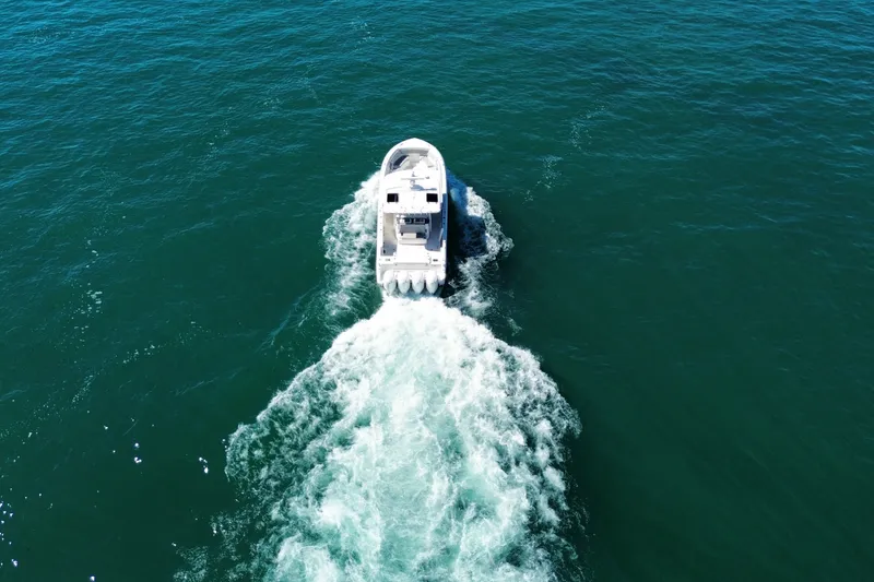 Slide: The Image of Aerial view of 2023 Pursuit S 428 Sport boat cruising on open water. - 7