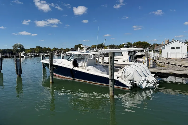 Slide: The Image of 2023 Pursuit S 428 Sport boat docked at marina under clear blue sky. - 9