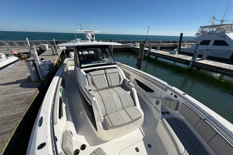 Slide: The Image of 2023 Pursuit S 428 Sport boat docked at marina, featuring luxurious seating and sleek design. - 25