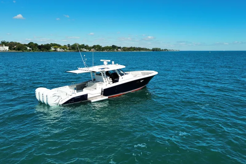 Slide: The Image of 2023 Pursuit S 428 Sport boat on open water under clear blue sky. - 6