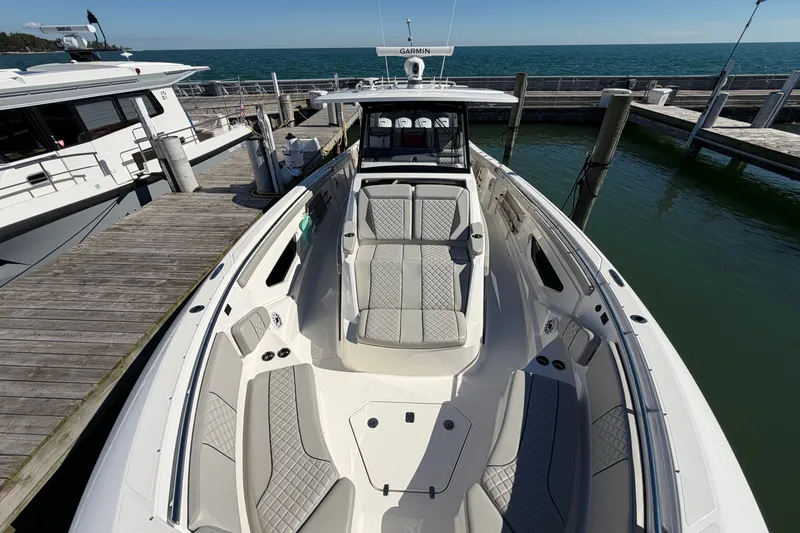 Slide: The Image of 2023 Pursuit S 428 Sport boat docked, featuring spacious seating and sleek design. - 26