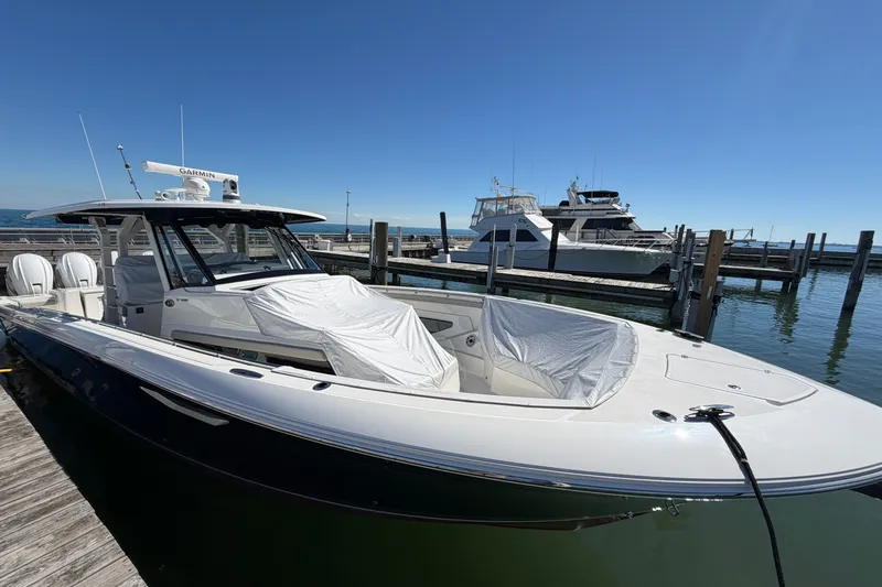 Slide: The Image of 2023 Pursuit S 428 Sport boat docked at marina under clear blue sky. - 36