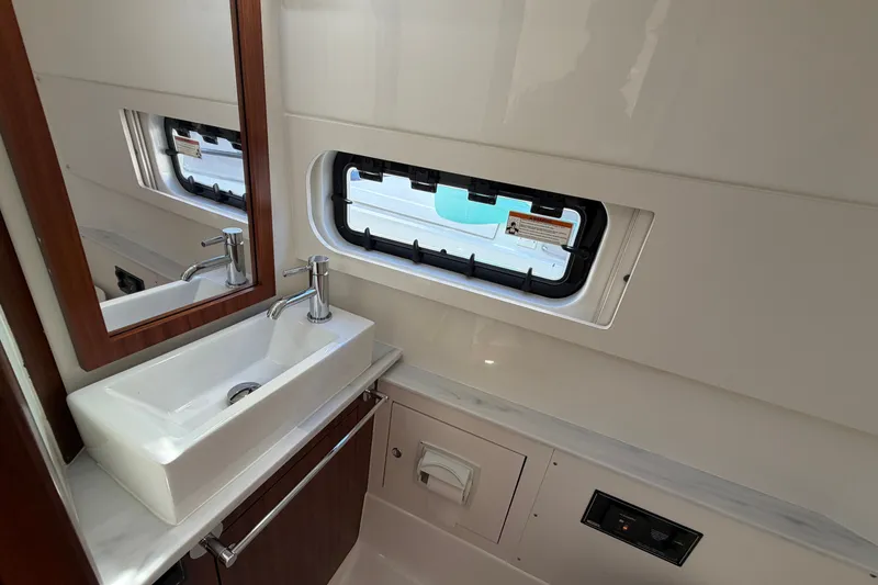Slide: The Image of 2023 Pursuit S 428 Sport boat bathroom with sink, mirror, and window. - 21