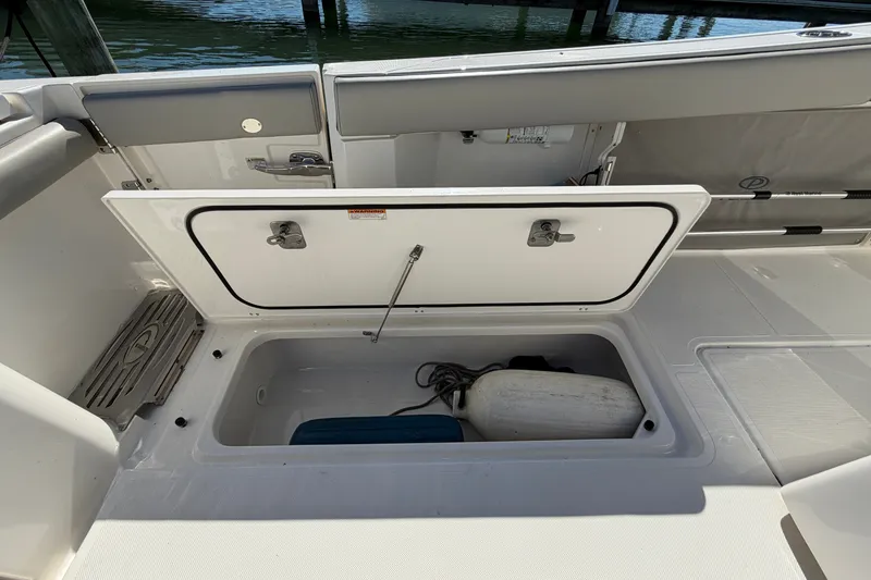 Slide: The Image of 2023 Pursuit S 428 Sport boat storage compartment with fender and equipment. - 34