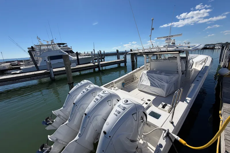 Slide: The Image of 2023 Pursuit S 428 Sport boat docked with powerful outboard engines. - 11