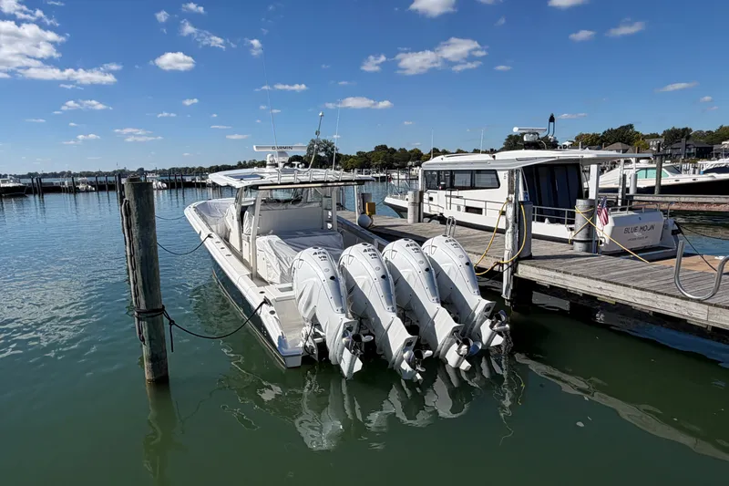 Slide: The Image of 2023 Pursuit S 428 Sport boat docked with four engines, under a clear blue sky. - 10