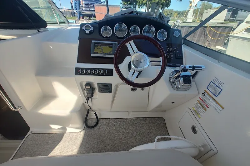 Slide: The Image of Cockpit of 2012 Sea Ray Sundancer 310 with steering wheel and navigation controls. - 14