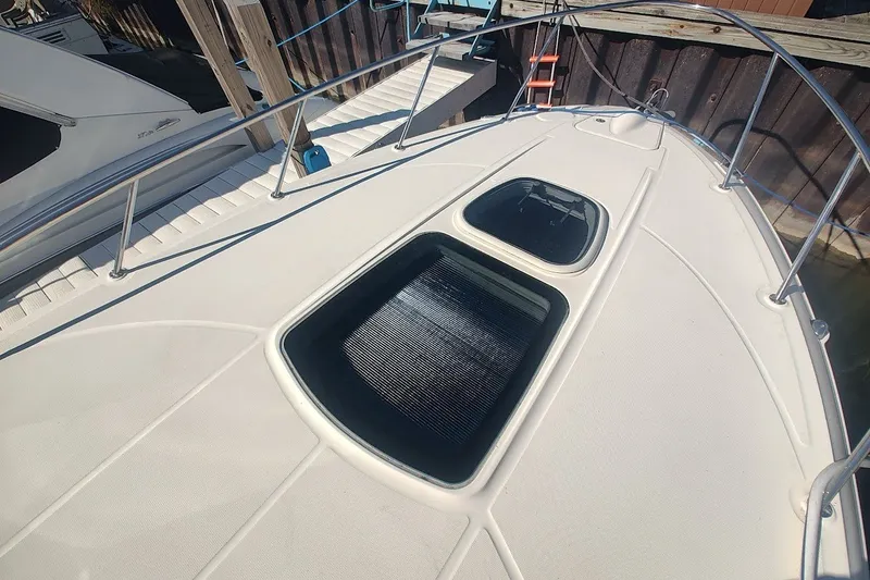Slide: The Image of 2012 Sea Ray Sundancer 310 boat deck with open hatch, docked at marina. - 38