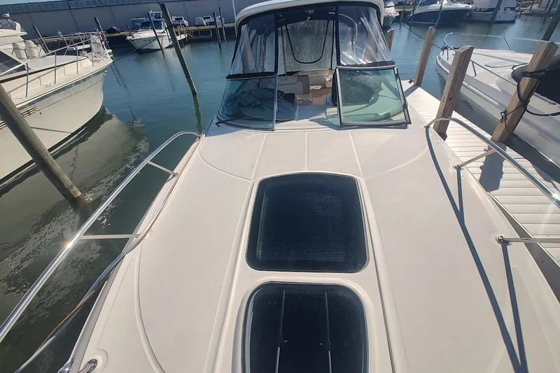 Slide: The Image of 2012 Sea Ray Sundancer 310 docked at marina, showcasing sleek deck design. - 41