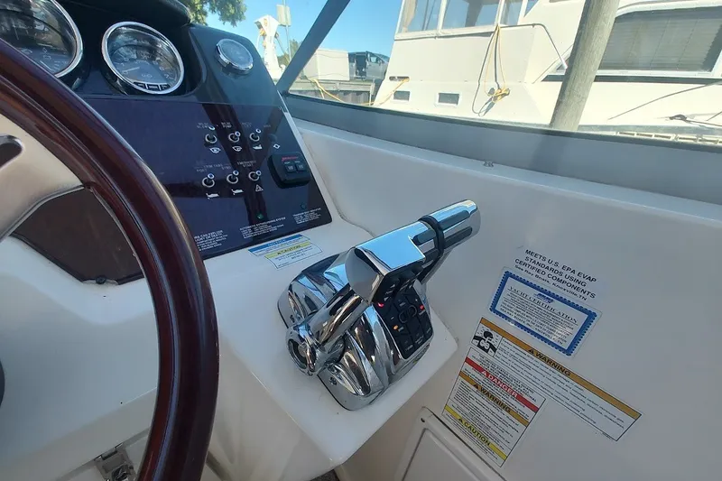 Slide: The Image of 2012 Sea Ray Sundancer 310 helm with controls and gauges, showcasing sleek design. - 15