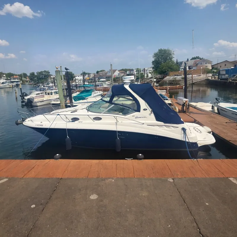 The Image of 2006 Sea Ray 320 Sundancer docked at a marina with blue canopy. - 0