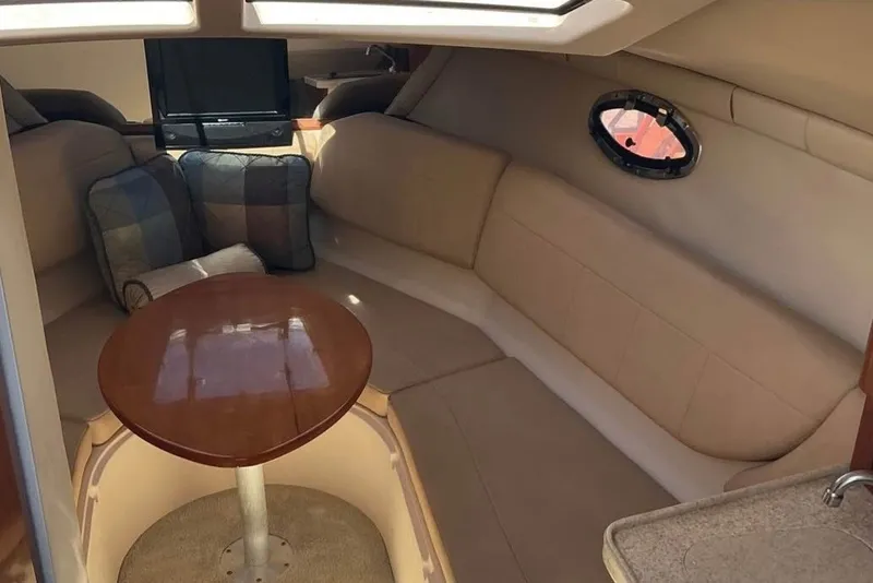 Slide: The Image of Interior of 2008 Regal 2565 Express Cruiser with cozy seating and wooden table. - 5