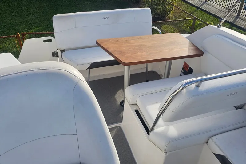 Slide: The Image of 2008 Regal 2565 Express Cruiser interior with white seating and wooden table. - 3