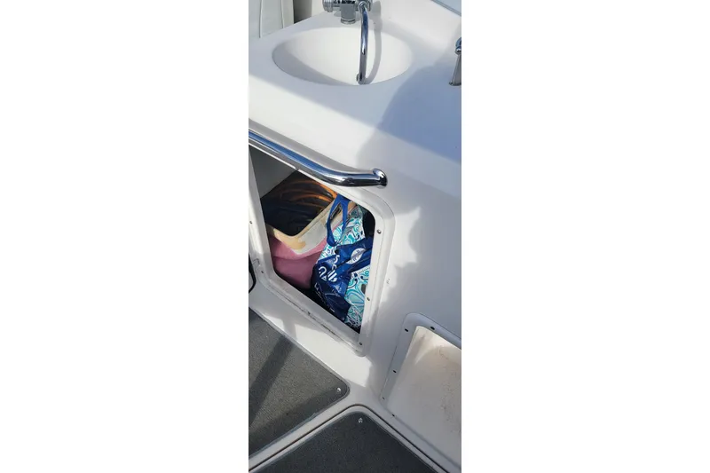 Slide: The Image of Storage compartment on a 2008 Regal 2565 Express Cruiser boat with colorful bags inside. - 12