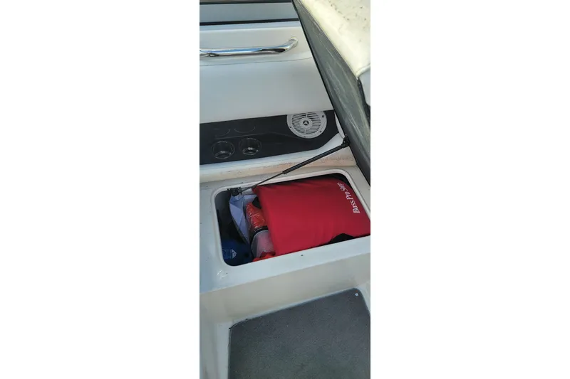Slide: The Image of Storage compartment in a 2008 Regal 2565 Express Cruiser boat, featuring a red bag. - 13