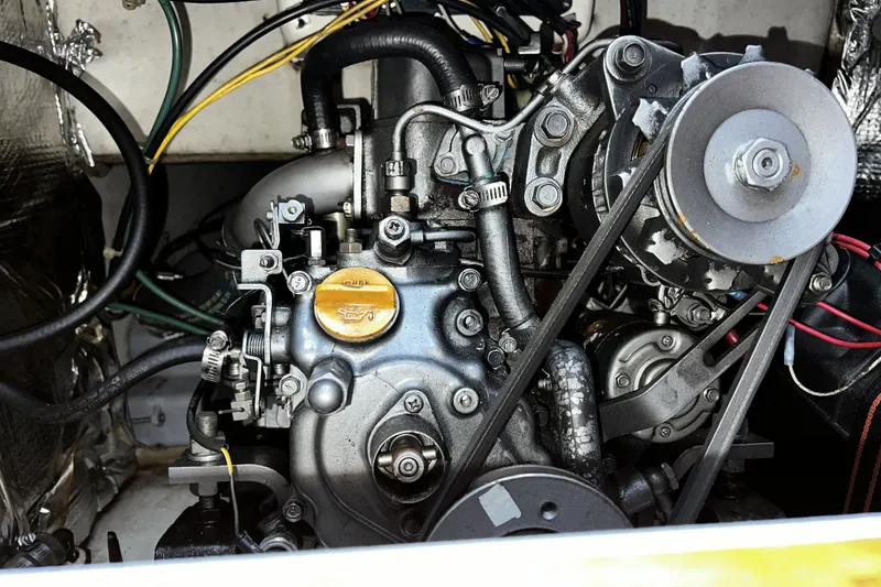 Slide: The Image of Engine of a 1995 Alerion Express 28 sailboat, showcasing mechanical components and belts. - 43