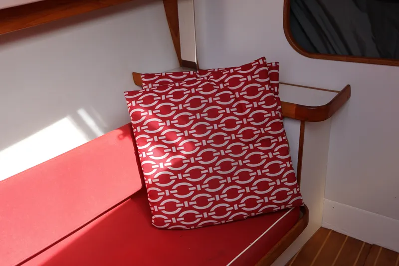 Slide: The Image of Red patterned cushions on a 1995 Alerion Express 28 sailboat interior. - 32