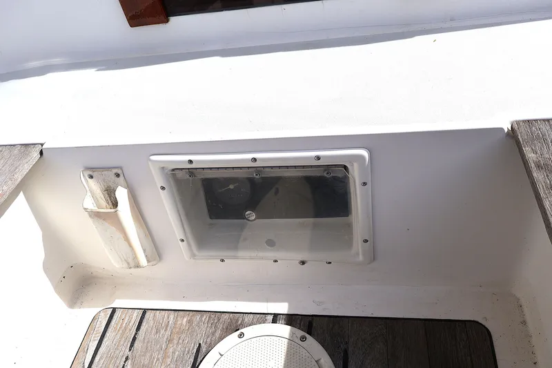 Slide: The Image of Cockpit detail of 1995 Alerion Express 28 sailboat, featuring a storage compartment and wooden flooring. - 14