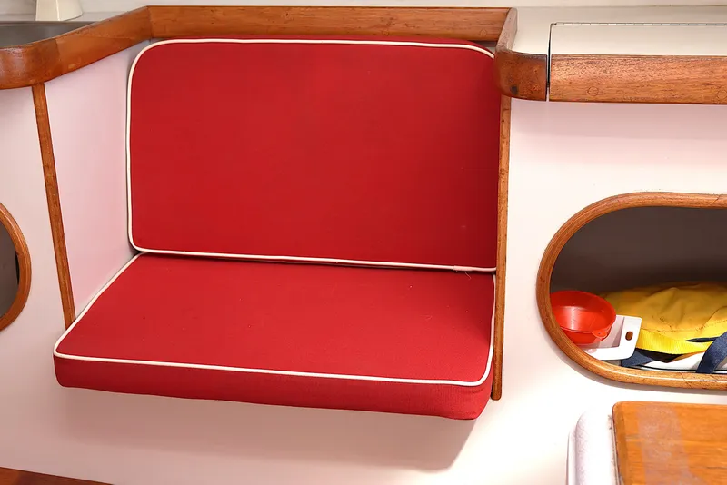 Slide: The Image of Red cushioned seat with wooden trim on a 1995 Alerion Express 28 sailboat. - 35