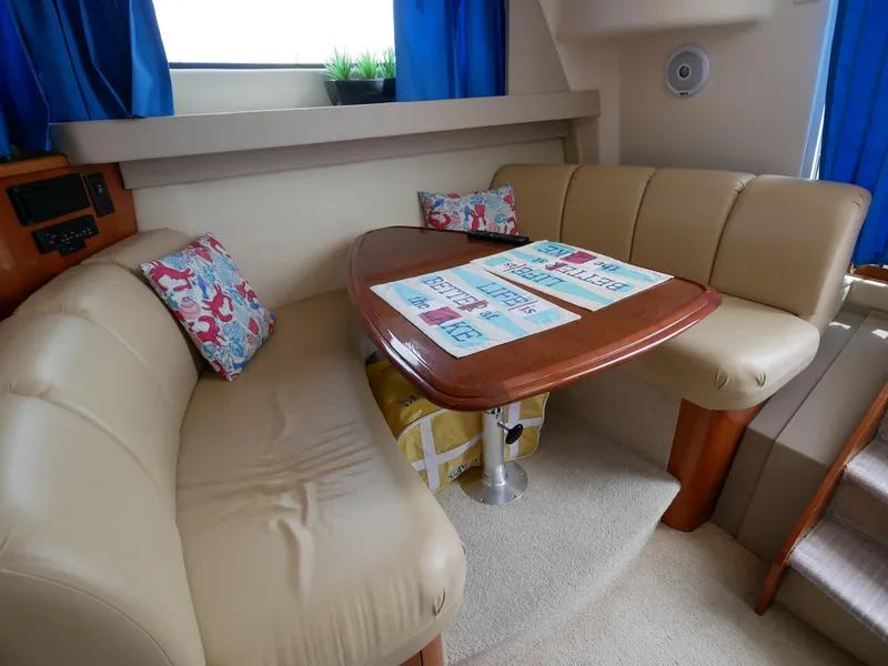 Slide: The Image of Der Innenraum einer Carver 360 Mariner von 2005 zeigt eine gemütliche Sitzecke mit einem Holztisch. - 38