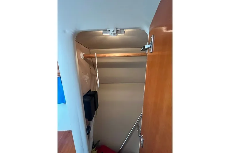 Slide: The Image of Interior closet of 2005 Carver 360 Mariner yacht with wooden door and hanging rod. - 55