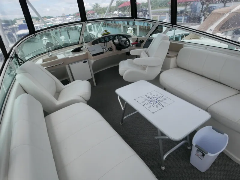 Slide: The Image of Das Bild zeigt das Cockpit einer Carver 360 Mariner von 2005 mit weißen Ledersitzen und einem Tisch. - 17