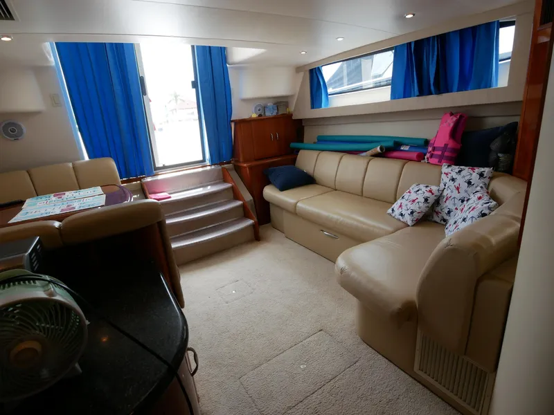Slide: The Image of Der Innenraum einer Carver 360 Mariner von 2005 zeigt ein gemütliches Wohnzimmer mit beigen Sofas und blauen Vorhängen. - 43