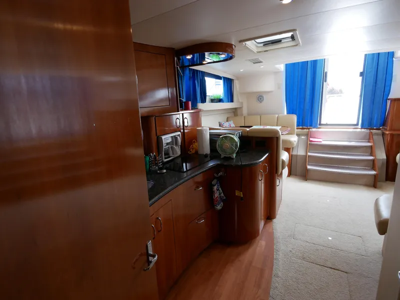 Slide: The Image of Innenansicht einer Carver 360 Mariner von 2005 mit Holzmöbeln und blauen Vorhängen. - 33