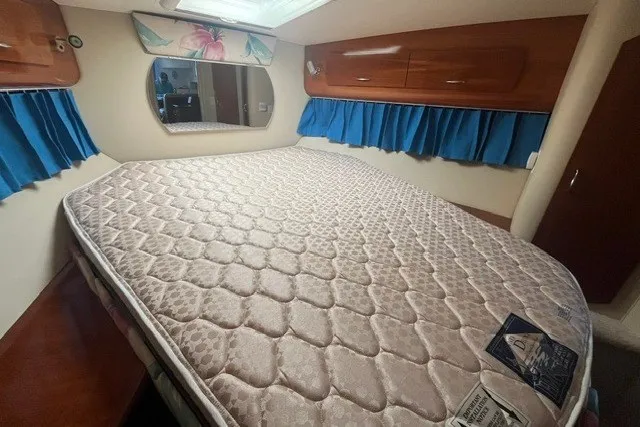 Slide: The Image of Interior cabin of 2005 Carver 360 Mariner with bed, blue curtains, and mirror. - 51