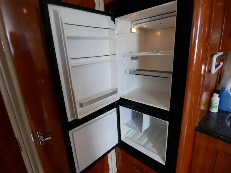 Slide: The Image of Ein geöffneter Kühlschrank in einer Bootskabine mit Holzverkleidung und Arbeitsplatte. - 40
