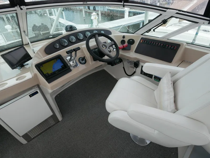 Slide: The Image of Das Cockpit der Carver 360 Mariner von 2005 zeigt ein modernes Steuerpult mit mehreren Instrumenten und einem bequemen weißen Kapitänssitz. - 19