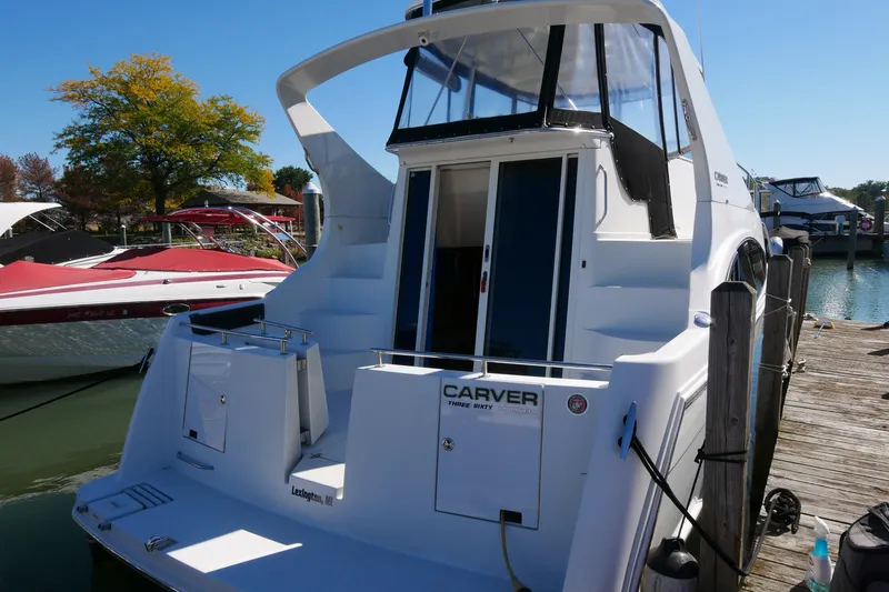 Slide: The Image of 2005 Carver 360 Mariner docked at a marina, showcasing its sleek design and spacious deck. - 8