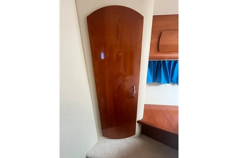 Slide: The Image of Interior of 2005 Carver 360 Mariner with wooden door and blue curtains. - 52