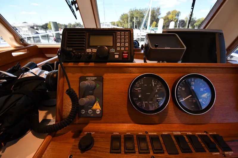 Slide: The Image of Control panel of a 2000 Mainship 390 Trawler with gauges and radio equipment. - 48