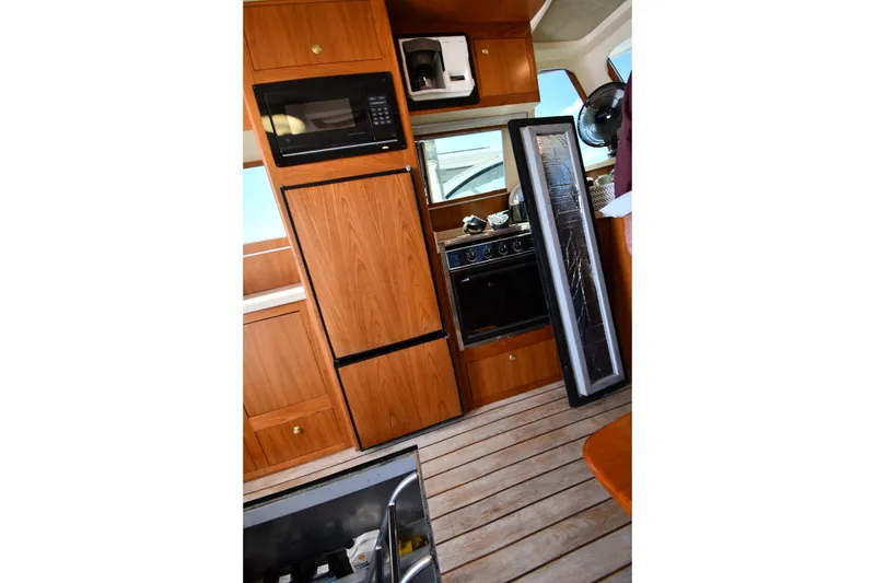 Slide: The Image of Interior of 2000 Mainship 390 Trawler with wooden cabinetry and kitchen appliances. - 59