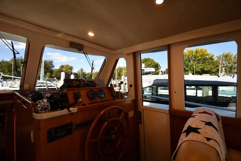 Slide: The Image of Interior view of 2000 Mainship 390 Trawler helm with steering wheel and navigation instruments. - 47