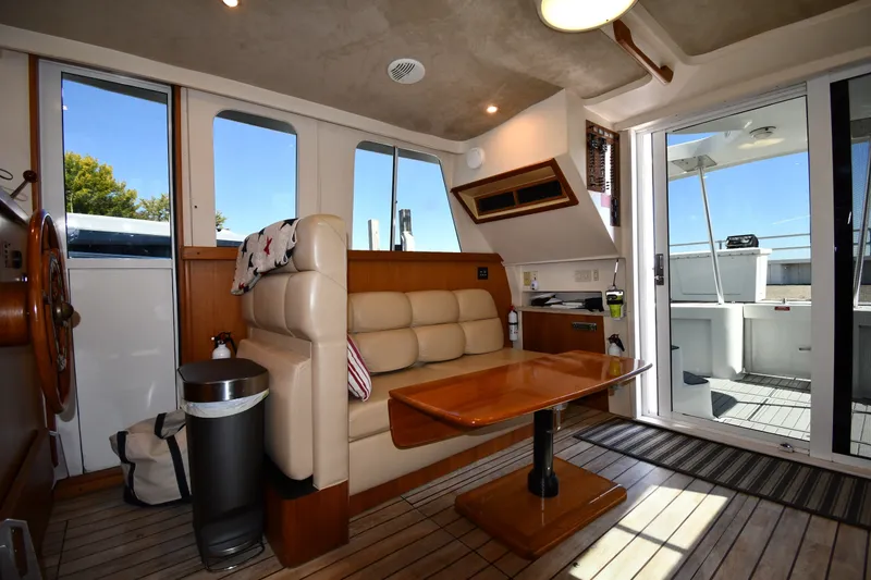 Slide: The Image of Interior of 2000 Mainship 390 Trawler with seating, table, and helm wheel. - 40
