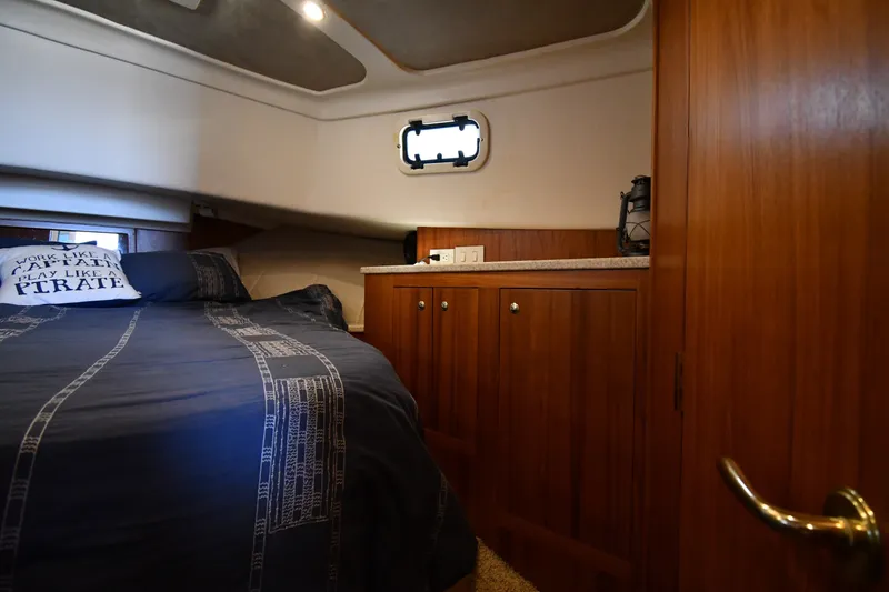 Slide: The Image of Cozy cabin interior of 2000 Mainship 390 Trawler with wooden cabinetry and nautical decor. - 27