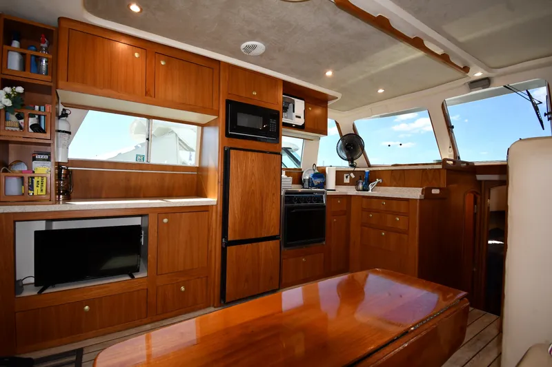 Slide: The Image of Interior of 2000 Mainship 390 Trawler with wooden cabinetry and modern kitchen amenities. - 38
