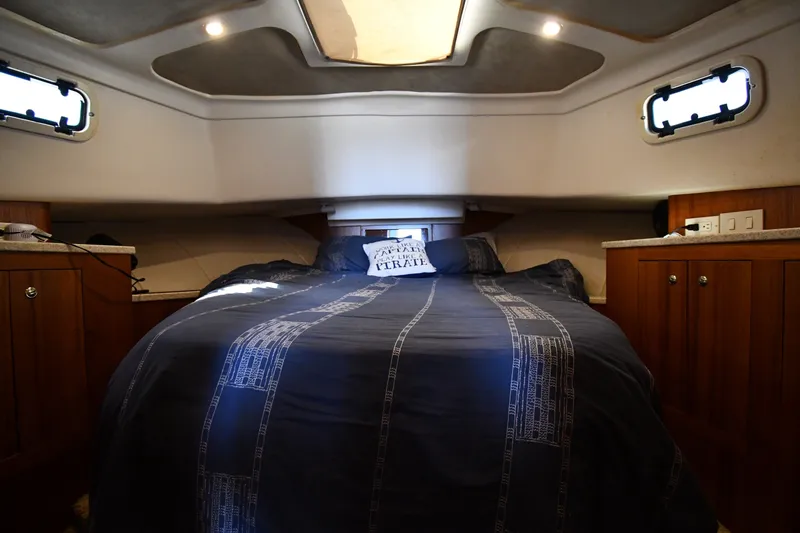Slide: The Image of Cozy cabin interior of 2000 Mainship 390 Trawler with bed and wooden cabinetry. - 26