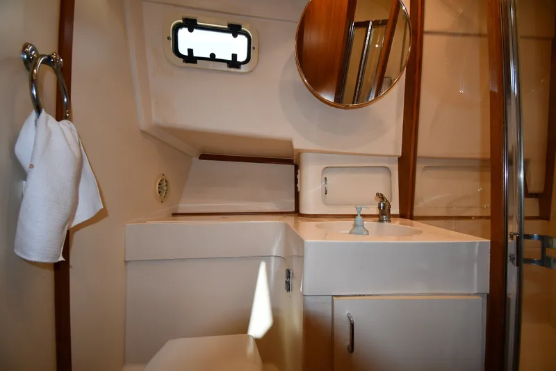 Slide: The Image of Bathroom interior of 2000 Mainship 390 Trawler with sink, mirror, and towel holder. - 33