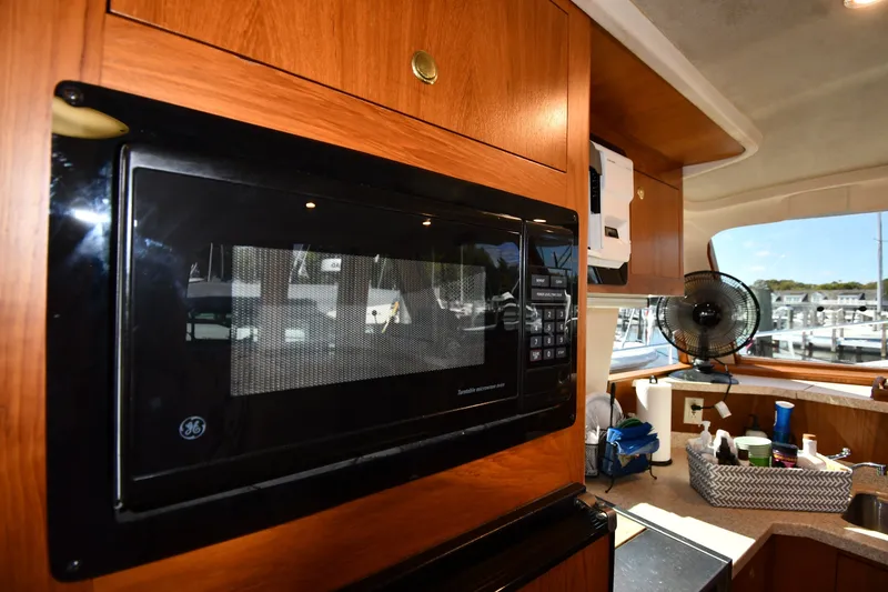 Slide: The Image of Interior of 2000 Mainship 390 Trawler with microwave and kitchen essentials. - 53