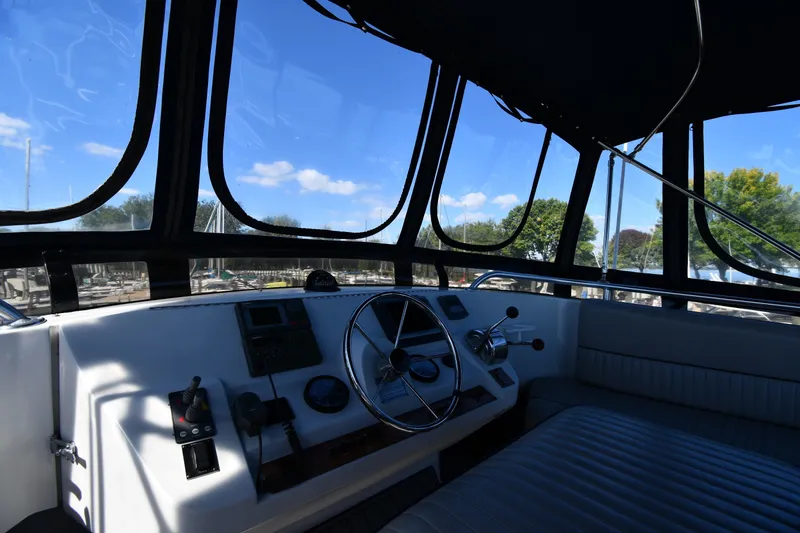 Slide: The Image of Interior view of 2000 Mainship 390 Trawler helm with steering wheel and controls. - 17