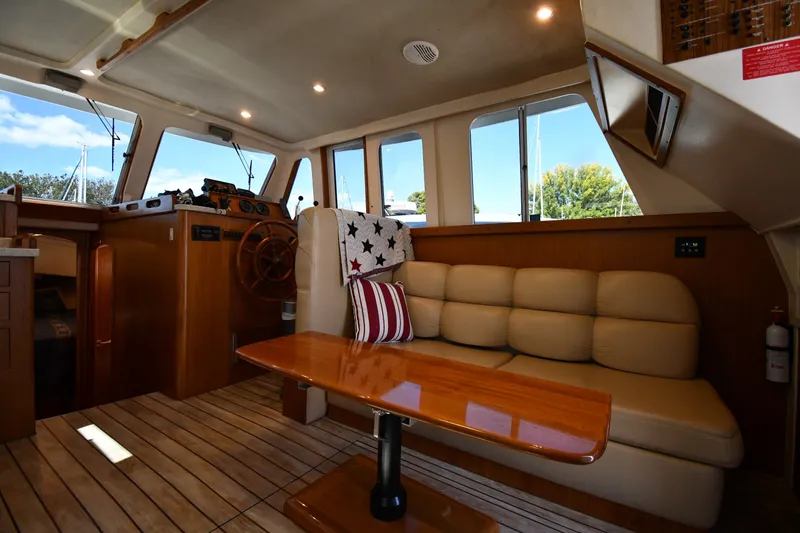 Slide: The Image of Interior of 2000 Mainship 390 Trawler with cozy seating and wooden accents. - 37