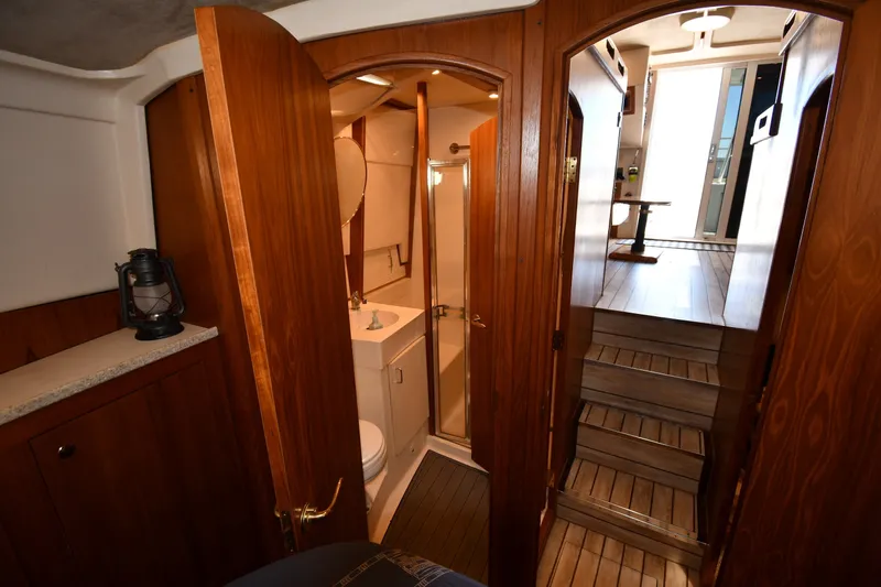 Slide: The Image of Interior of 2000 Mainship 390 Trawler featuring wooden cabinetry and compact bathroom. - 31