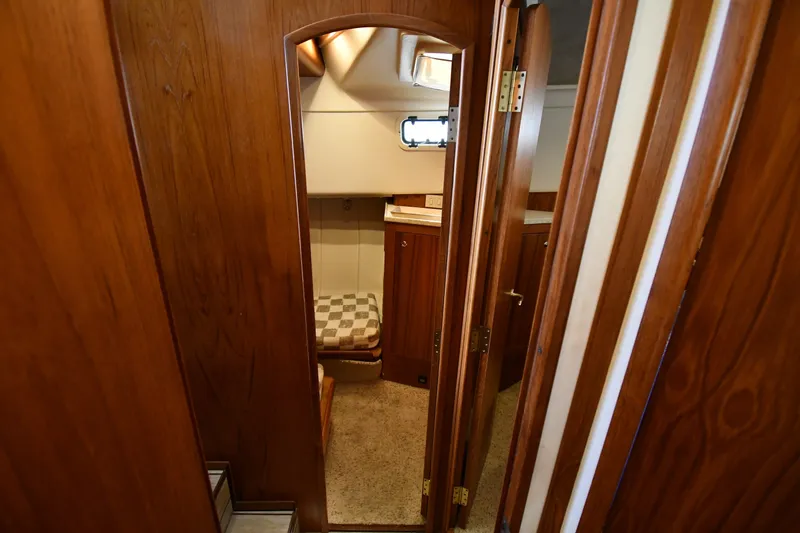 Slide: The Image of Interior view of 2000 Mainship 390 Trawler, featuring wooden cabinetry and cozy seating area. - 34
