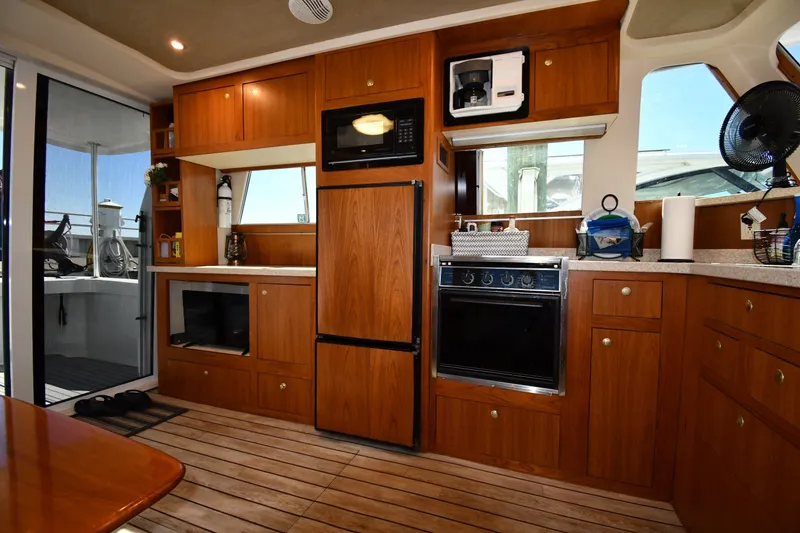 Slide: The Image of Interior of 2000 Mainship 390 Trawler with wooden cabinetry and modern kitchen appliances. - 39