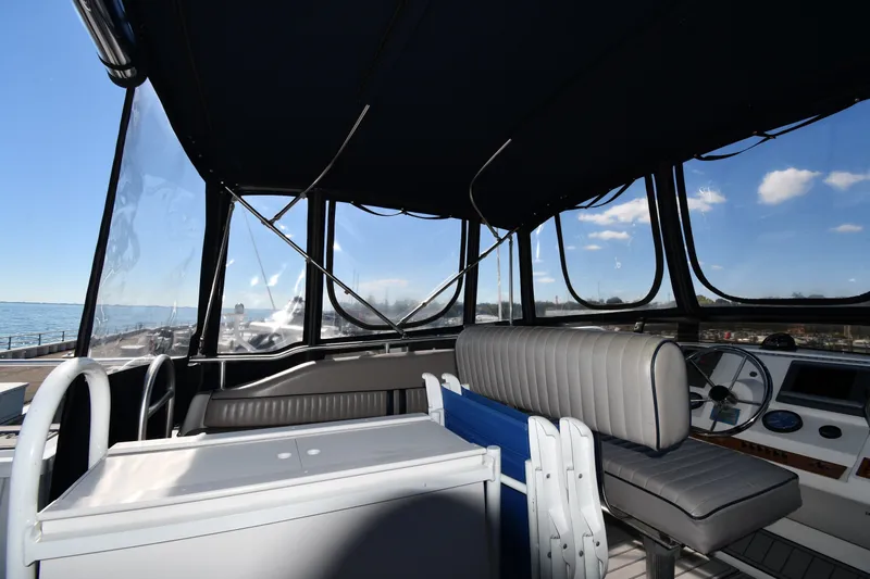 Slide: The Image of Interior view of 2000 Mainship 390 Trawler helm with seating and steering wheel. - 22
