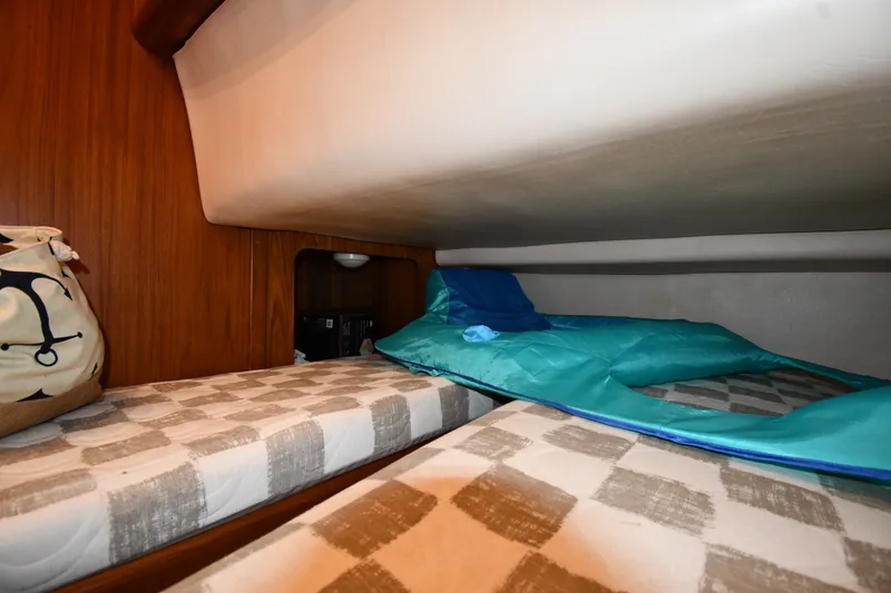 Slide: The Image of Cozy sleeping area in 2000 Mainship 390 Trawler with patterned cushions and storage. - 36